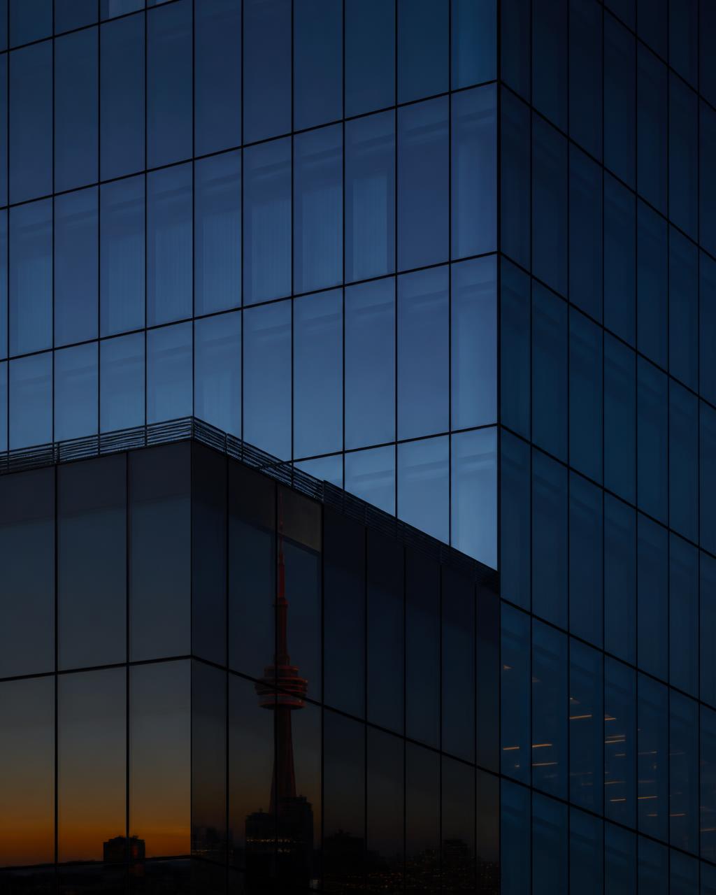 Glass tower facade in Toronto reflecting a cold blue dusk